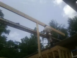 Carpenter setting a ridge beam over a new addition frame — Ice Dam Removal by Roofing Brothers in Rochelle Park