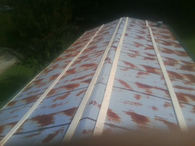 Rusted metal roof panels with new wood purlins before replacement — Storm Damage Roof Repair in Rochelle Park by Roofing Brothers