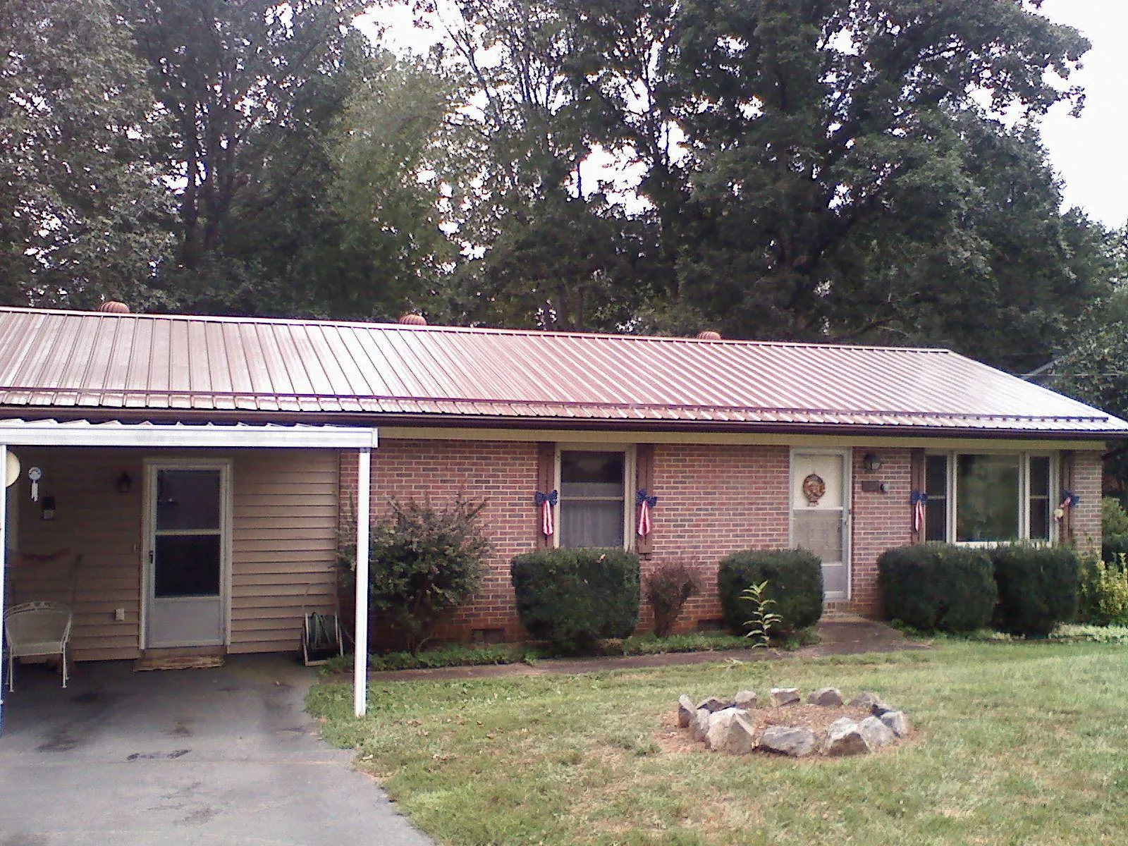 Bronze metal roof and carport on a brick ranch home — Roof Repair work by our crew in Rochelle Park